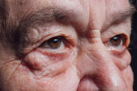 Seniors eyes close up, contemplative old caucasian woman staring at camera. Macroの写真素材