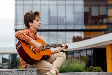 Preteen plays guitar in the parkの写真素材
