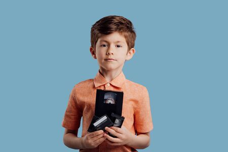 Little boy with video tape isolated on blueの写真素材