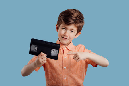 Little boy pointing to video tape on blueの写真素材