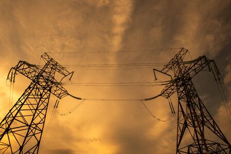 Electrical Grid and Transmission Line at Dusk. Electricity Pylons Against Sky at Sunset. Clouds Moving Across Sky. Ecology conceptの写真素材
