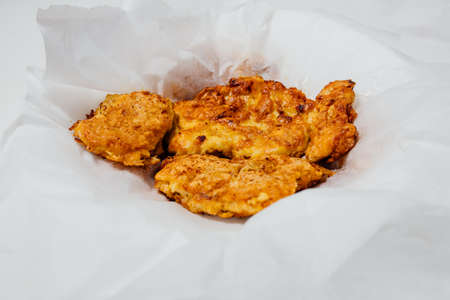 High angle of appetizing roasted chicken in batter on napkin in bowl on white background in studioの写真素材