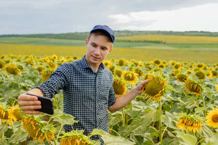 young farmer blogger influencer recording video blog concept speaking looking at smartphone farmer vlogger shooting vlog, streaming online podcast on mobile phoneの写真素材