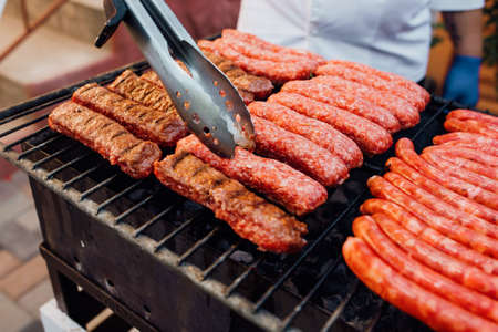 close up. Tasty sausages sizzling on a portable BBQ fire grilling on a summer picnic,  Grilling food, bbq, barbecueの写真素材