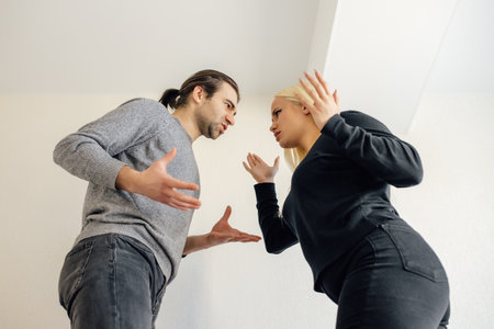 Could you just hear me? family wife and husband quarrelling, having conflict. Upset couple at home. Handsome man and beautiful young woman are having quarrel.の写真素材