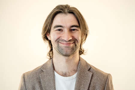 handsome young man looks at the camera and smile slightly, studio shot,の写真素材