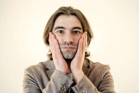 Bearded hispter man touching his face with hands. young man with palms on faceの写真素材