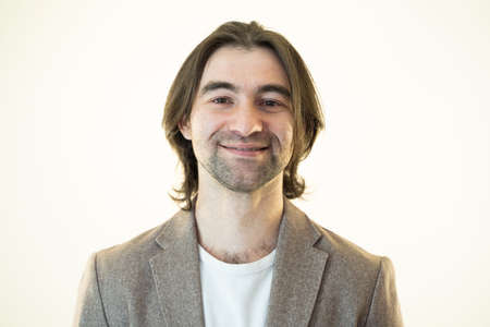 handsome young man looks at the camera and smile slightly, studio shot,の写真素材