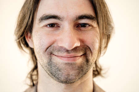 close up shot of young man. is smiling looking at camera smiling pleasantly, studio shot, cropの写真素材