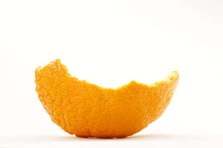 orange peel isolated on a white background. Single orange skin. Tangerine peel on the white table. mandarin peel isolated against white backgroundの写真素材