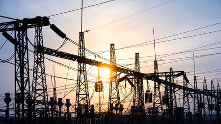 Impression network at transformer station in sunset, high voltage up to blue sky take with blue tone, horizontal frame. electrical distribution stationsの写真素材