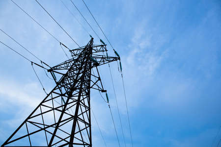 Electricity pylons on blue sky background. High voltage grid tower with wire cable at distribution station. energy industry, energy savingの写真素材