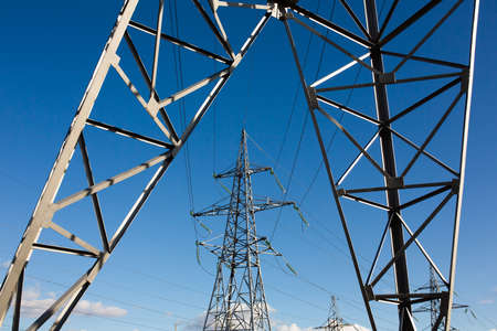 Electricity pylons on blue sky background. High voltage grid tower with wire cable at distribution station. energy industry, energy savingの写真素材