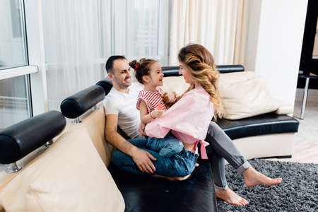 Happy young family staying at home. family enjoying tender moment, smiling parents and preschool children having fun togetherの写真素材