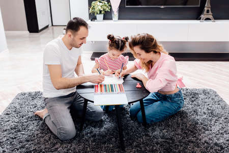 Happy young family staying at home. family enjoying tender moment, smiling parents and preschool children having fun togetherの写真素材