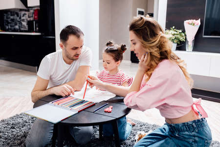 Happy young family staying at home. family enjoying tender moment, smiling parents and preschool children having fun togetherの写真素材