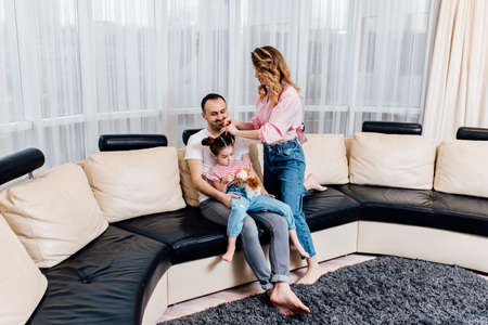 Happy young family staying at home. family enjoying tender moment, smiling parents and preschool children having fun togetherの写真素材