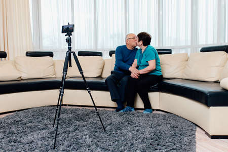 Elderly families by recording videos for broadcast in the social world. Happy family activity together. technology, blogging and people concept. kissの写真素材