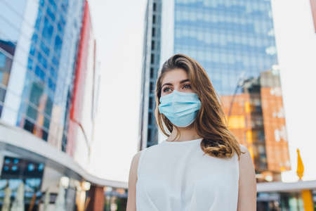 portrait of young woman with mask for protection from virus outbreak, at the townの写真素材
