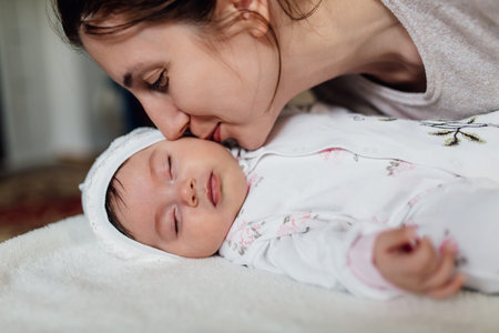 Close up portrait of Mother kissing her little 2 months old baby. family, child and parenthood...