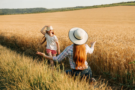 happy farmer mother with hat waiting for her happy running girl. childhood in rural happiness. families of farmers, women and kid.の写真素材