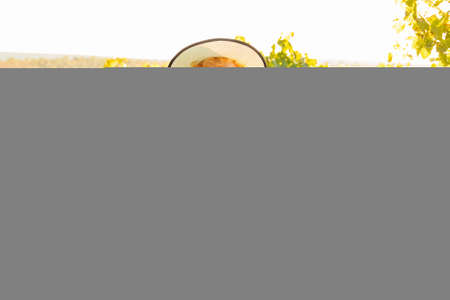 winemaker woman with hat showing thumb up and looking at camera. Happy owner of agriculture small business is rejoicing at her success.の写真素材