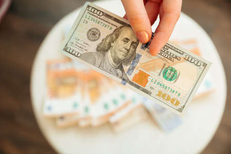 hands showing dollars banknotes. Finance and business concept. euro and pound on the background. Counting holding and showing money or giving money concept.の写真素材