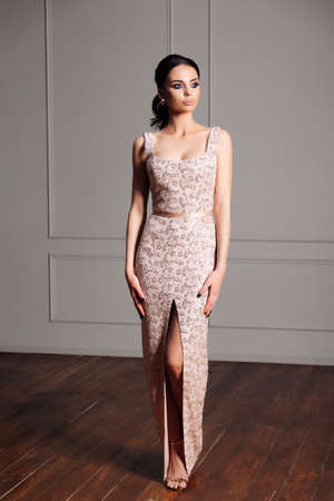 brunette young woman in beige evening dress, luxury elegance, fashion shot, vintage interior.の写真素材