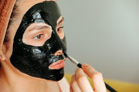 close up of a applying the cosmetic mask on the womans face. wears towel on head, cares of beauty, wants to be young and fresh, Wellness conceptの写真素材