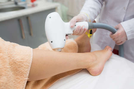 close up view of womans leg getting laser treatment on her legs, beauty concepts, medical laser.の写真素材