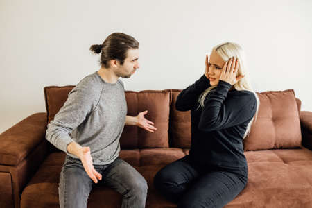 Angry man shouted at his wife, who covered her ears with her hands. family crisis conflict conceptの写真素材