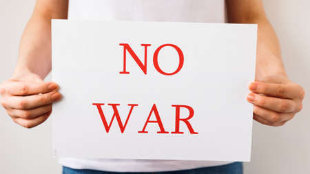 close up of a Protester hands holding cardboard Banner with the words no war. protesting against the Russian invasion. banner inscription cardboard massage Hands Off Ukraine.の写真素材