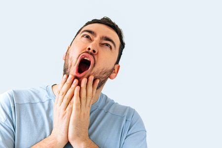 screaming bearded brutal man, shocked aggressive young annoyed bearded man bad mood isolated on beige color background. Shouting maleの写真素材