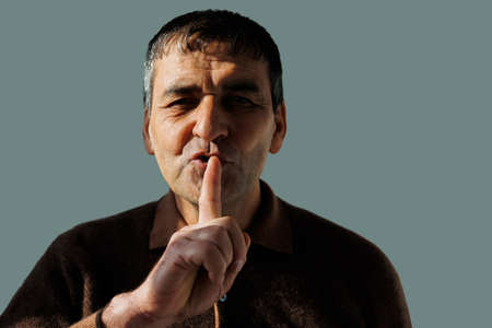 worried Asian eledrly man looking at camera and putting finger on lips. Censorship concept, Secret information. isolated on a white backgroundの写真素材