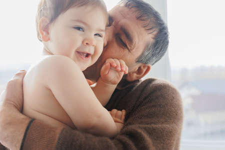 Happy senior grandpa and cute kid granddaughter playing having fun game at home. Two generations family grandparent and little grandchild, having fun enjoying handcraft hobby concept at homeの写真素材