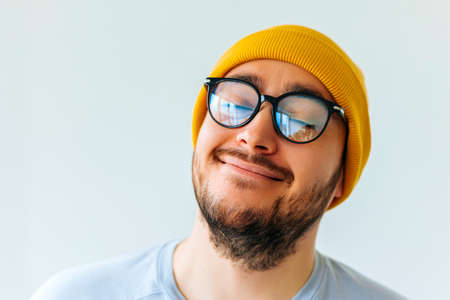 Happy young bearded man with glasses and yellow hat cap. Portrait of handsome young man in casual shirt nice middle age man with a happy face standing and smilingの写真素材