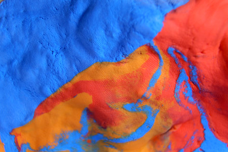 Mixing colours Blue, red and yellow creating pattern pink paint. close up relief, selective focusの写真素材