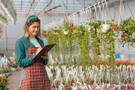 caucasian woman used notebook to analysis and record the data of color flowers, experiment in the...