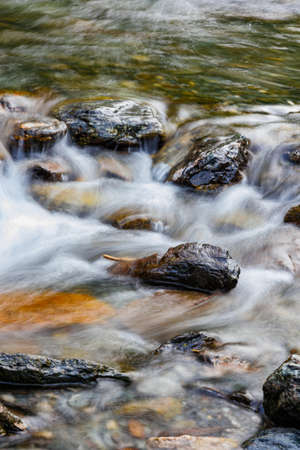 long exposure of a River stream on mountain valley. Slow motion surface boiling water in the mountain river. Fresh water bubbling from source. croppedの写真素材