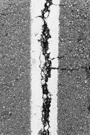 cropped background texture of rough Cracked asphalt.の写真素材