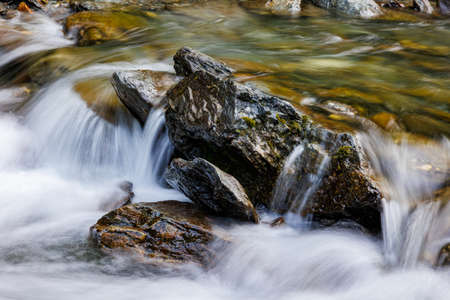 long exposure of a River stream on mountain valley. Slow motion surface boiling water in the mountain river. Fresh water bubbling from source. croppedの写真素材