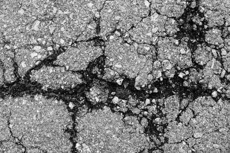 cropped background texture of rough Cracked asphalt.の写真素材