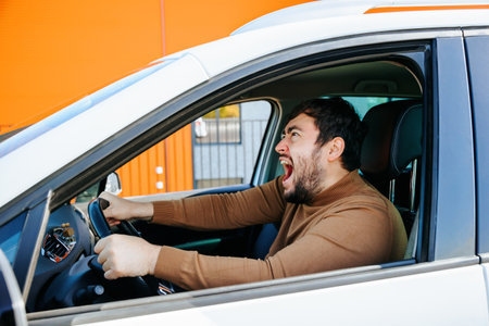 hispanic chauffeur bearded man yelling, screaming and mad, furious and crazy with negative emotion facial expression. driver young, middle age male is stressed, upset and angry,の写真素材