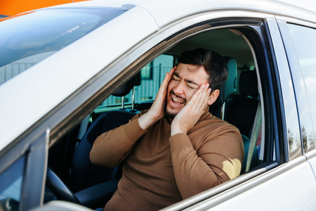 Tired mature driver hand on head waiting in traffic and contemplating about job problems. man having a headache has to make a stop after driving a car in a traffic jam. Stressed man driverの写真素材