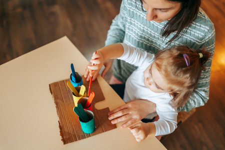 Top view of a young woman with a little girl doing children activities, interesting educational games. workplace. Educational games for children concept.の写真素材