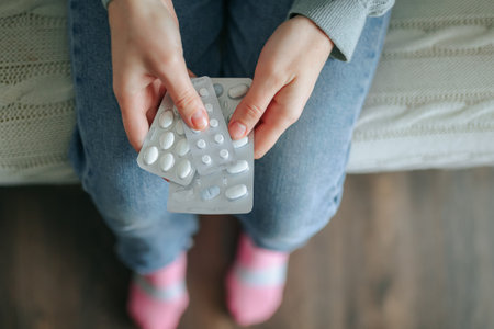 Unrecognizable hands girls hold three blisters with different pills, from different diseases. Pills of different sizes and different shapes. At home, indoors. Top viewの写真素材