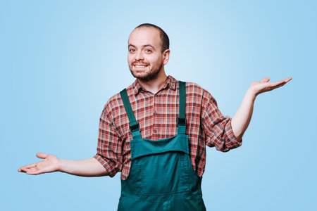 expressive workman in a coverall is captured in a moment of pure, unadulterated happiness, his laughing expression and outstretched hands conveying a sense of joy and delight. copy space, studio shotの写真素材