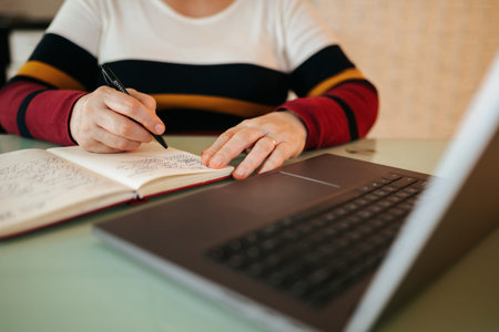 E-Learning at Home A Close-Up of a Womans Hands Typing on a Laptop. a woman Her hands are...