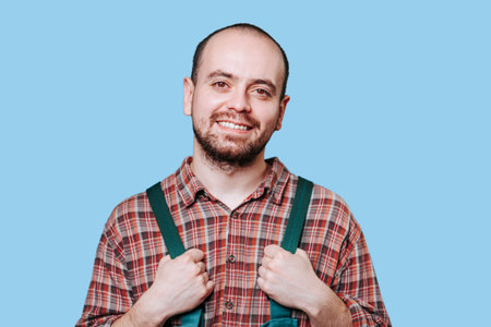 The guy, dressed in workman attire, exudes a sense of contentment and assurance as he looks directly at the camera, his eyes conveying a deep sense of pleasure. copy spaceの写真素材