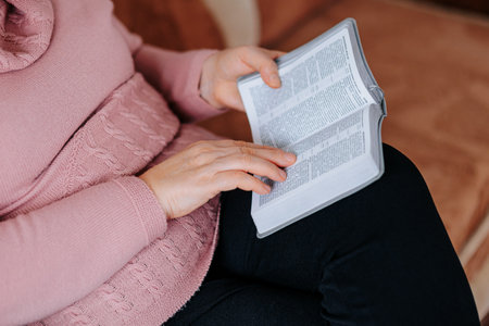 Old Woman Close-Up Hands Holding a Textbook for Studying and Learning at Home, Senior Bookworm Close-Up of Cropped Hands Holding Bookの写真素材
